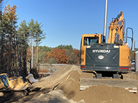 Machines work land around the common borrow.